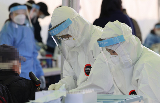 26일 오전 서울역 광장에 설치된 중구 임시 선별검사소에서 의료진이 검체를 채취하고 있다. 중앙방역대책본부는 이날 0시 기준으로 코로나19 신규 확진자가 1132명 늘어 누적 5만5902명이라고 밝혔다.  연합뉴스